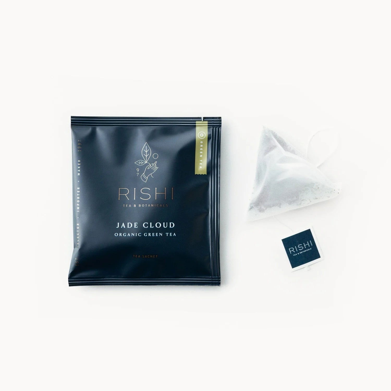 A packaged Jade Cloud green tea sachet alongside an open sachet with tea leaves visible, on a white background.