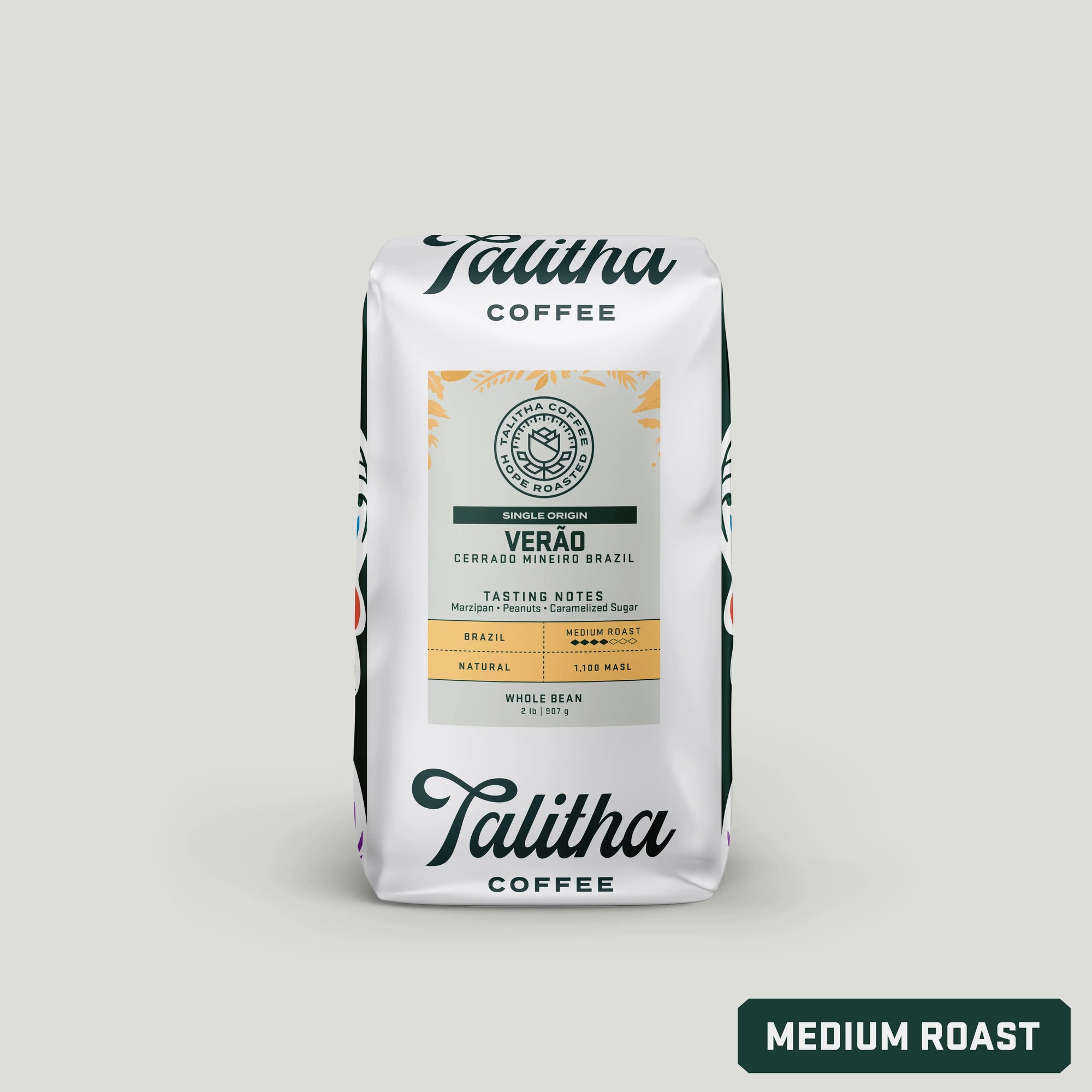 A package of Talitha Coffee, featuring a single origin Brazil coffee named 'Verão'. The packaging is white with a colorful floral pattern and text detailing the coffee's tasting notes and roast level, which is medium roast.